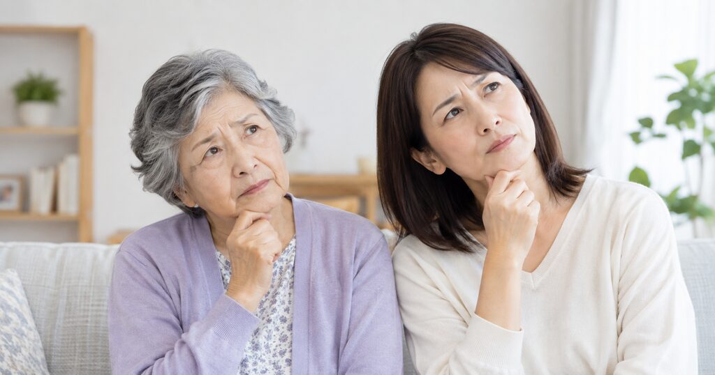 首をかしげる高齢女性と中年女性