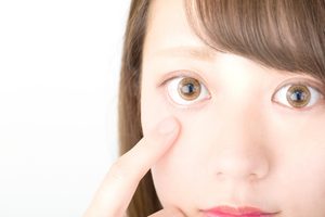 下まぶたを押さえている20代女性