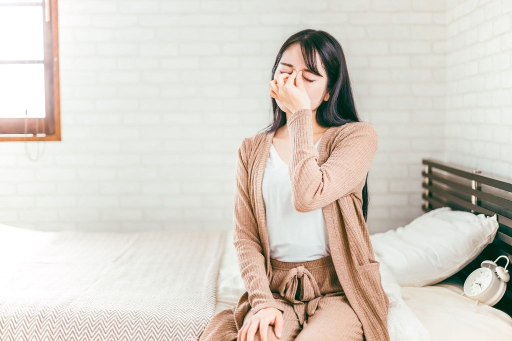 目を押さえている女性
