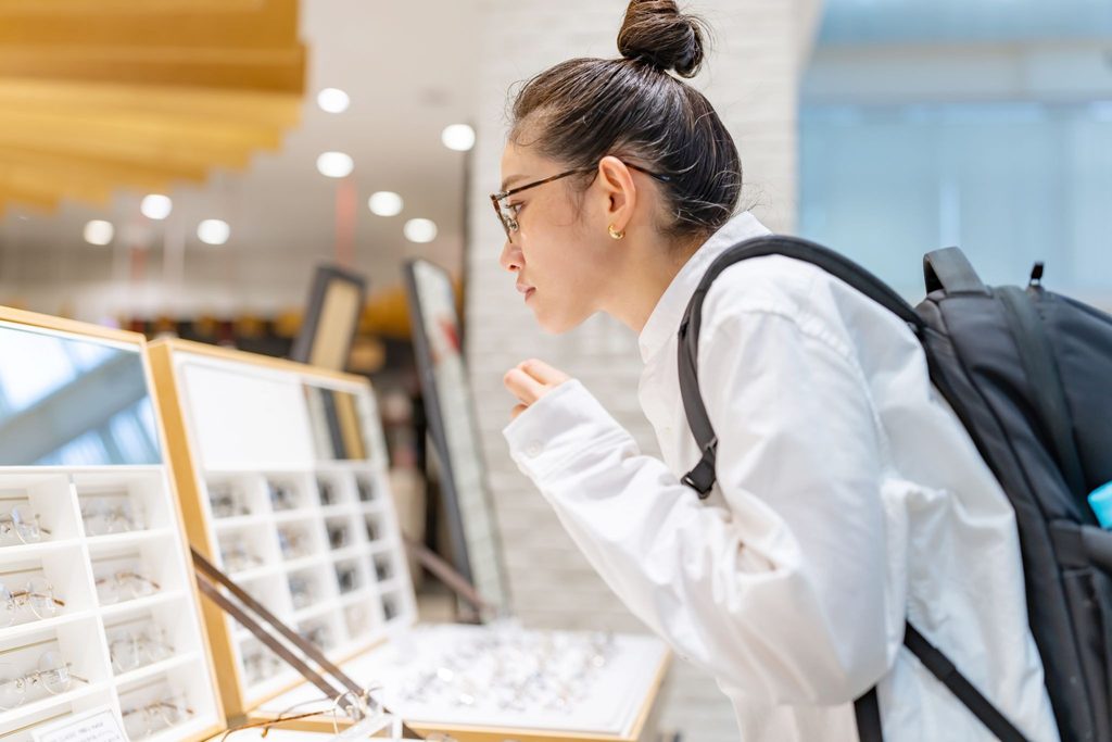 メガネ店でメガネを選んでいる女性