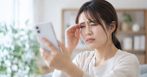 スマホを見ている近視の女性