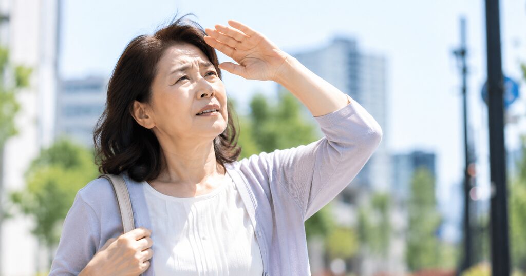 眩しそうにしている白内障の高齢女性
